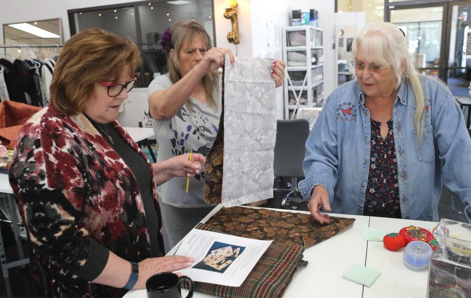 Jan Kearns, executive director of the Redding Fashion Alliance, left, and volunteers Kim Santry of Redding and Karen 
Flynn of Shingletown go over instructions for making joey pouches for wildfire who survived the Australian wildfires. A group of about a dozen volunteers met at the fashion alliance office Thursday, Jan. 9, 2020, to begin the sewing project.