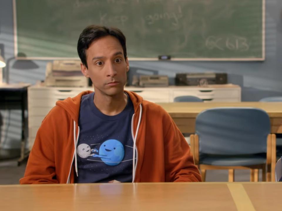 abed and britta on community. abed, played by danny pudi, is wearing a tshirt with the earth and a moon on it drawn by nathan pyle