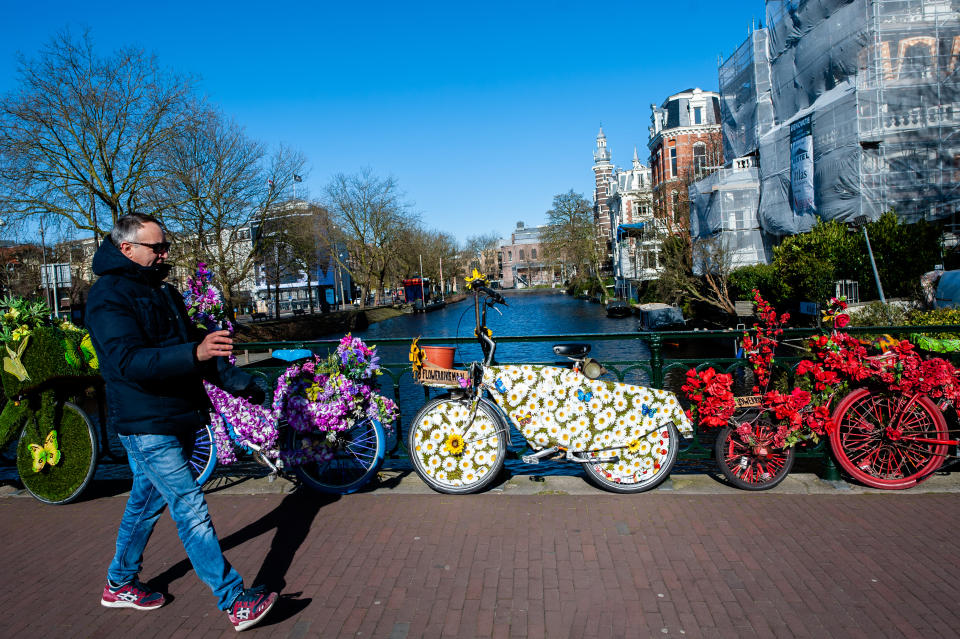 Un turista observa bicicletas decoradas con flores en Amsterdam, durante la crisis del coronavirus, en marzo 23, 2020. (Foto: Romy Arroyo Fernandez/NurPhoto via Getty Images)