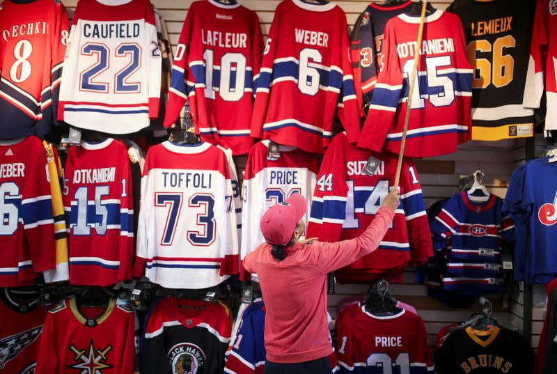 A store manager pulls down a Montreal Canadiens hockey jersey on display in his store in downtown Montreal