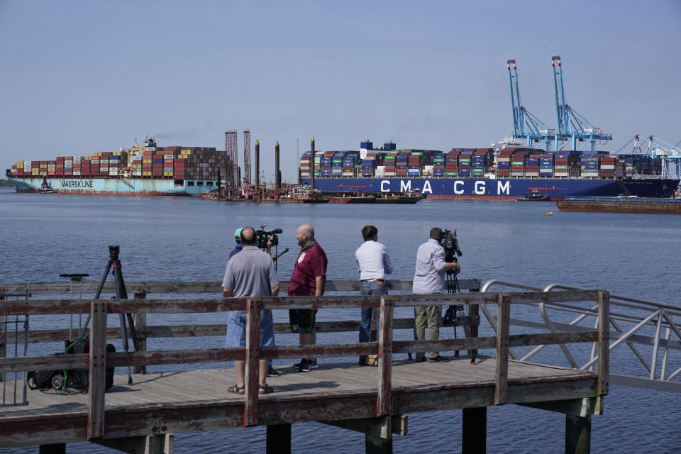 As people watch, the CMA CGM Marco Polo, right, docks at the Elizabeth-Port Authority Marine Terminal, as seen from Bayonne, N.J., Thursday, May 20, 2021. When the CMA CGM Marco Polo docks in New Jersey Thursday it will set a record for the largest container ship ever to visit the East Coast, a reflection both of the New York/New Jersey port system's multibillion-dollar efforts to accommodate larger ships and of the surging demand nationwide for products as COVID-19 restrictions continue to ease. (AP Photo/Seth Wenig)