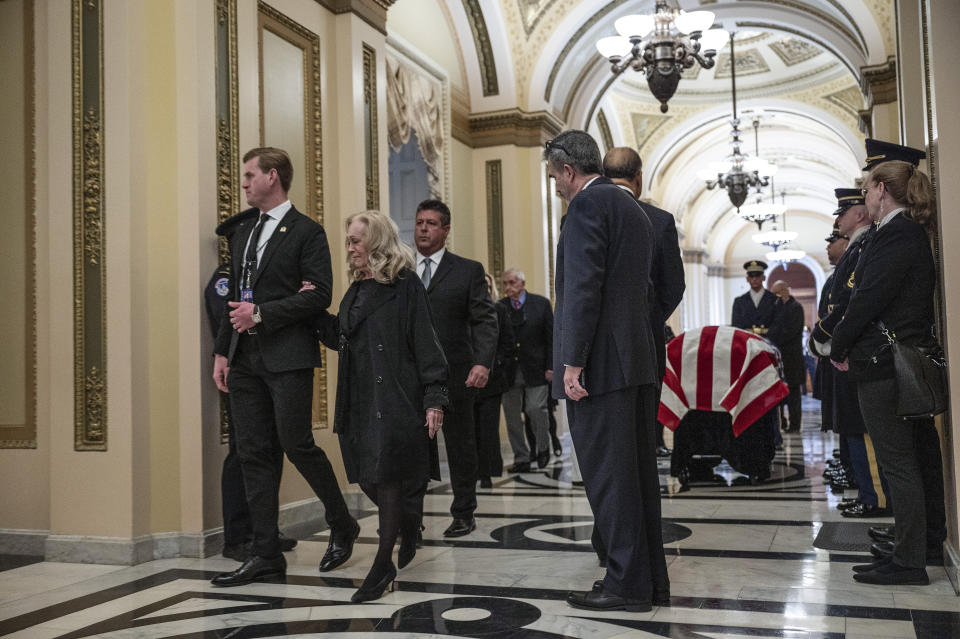 Anne Young, second from left, is escorted past the casket of her husband, former Rep. Don Young, R-Alaska, before a ceremony for her husband at the U.S. Capitol in Washington, Tuesday, March 29, 2022. (Jim Watson/Pool Photo via AP)