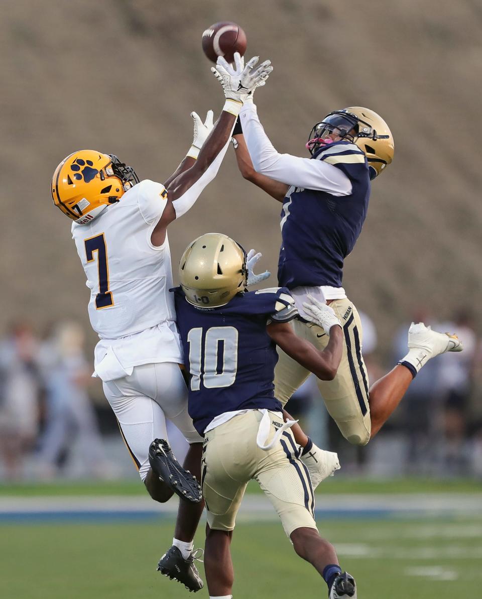 Hoban defensive backs Tysen Campbell, right, and Tylan Boykin, center, break up a pass intended for St. Ignatius wide receiver Brandon Webster on Sept. 16, 2022, in Akron.