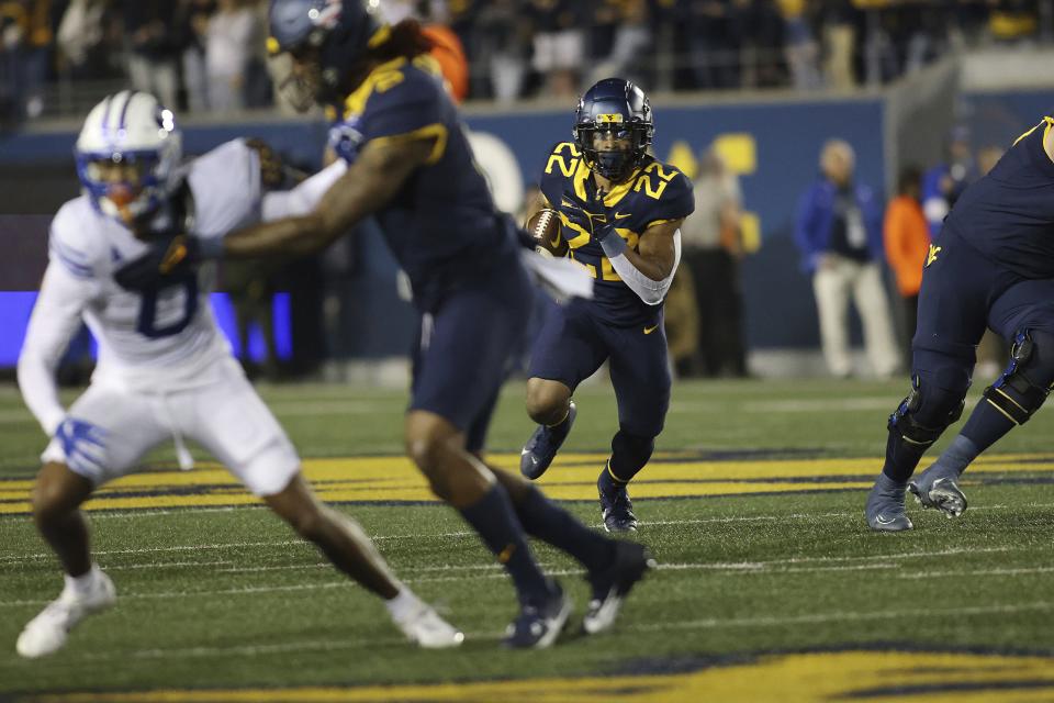 West Virginia’s Jaheim White (22) carries the ball during the first half of an NCAA college football game against BYU on Saturday, Nov. 4, 2023, in Morgantown, W.Va. West Virginia won 37-7.