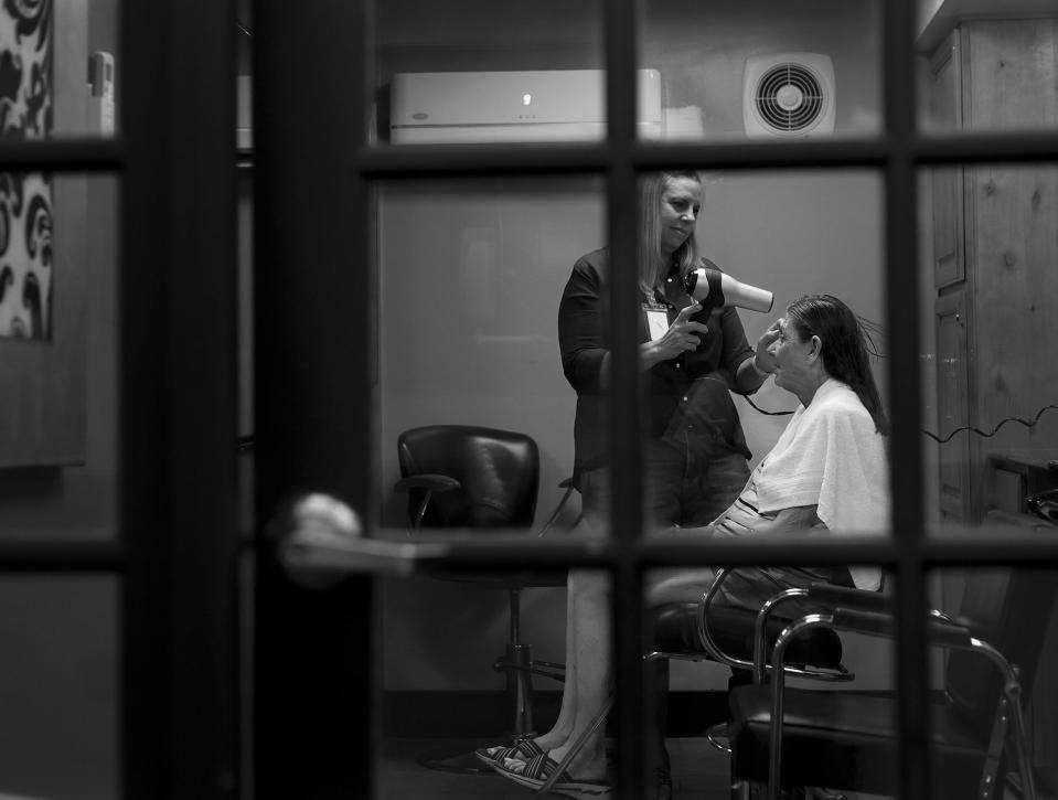 Chrissy Metcalf, a hairstylist who has been volunteering her time at The INN Between for more than seven years, gives Patti Larsen a shampoo and blow-dry on Friday, Aug. 5, 2022. | Laura Seitz, Deseret News