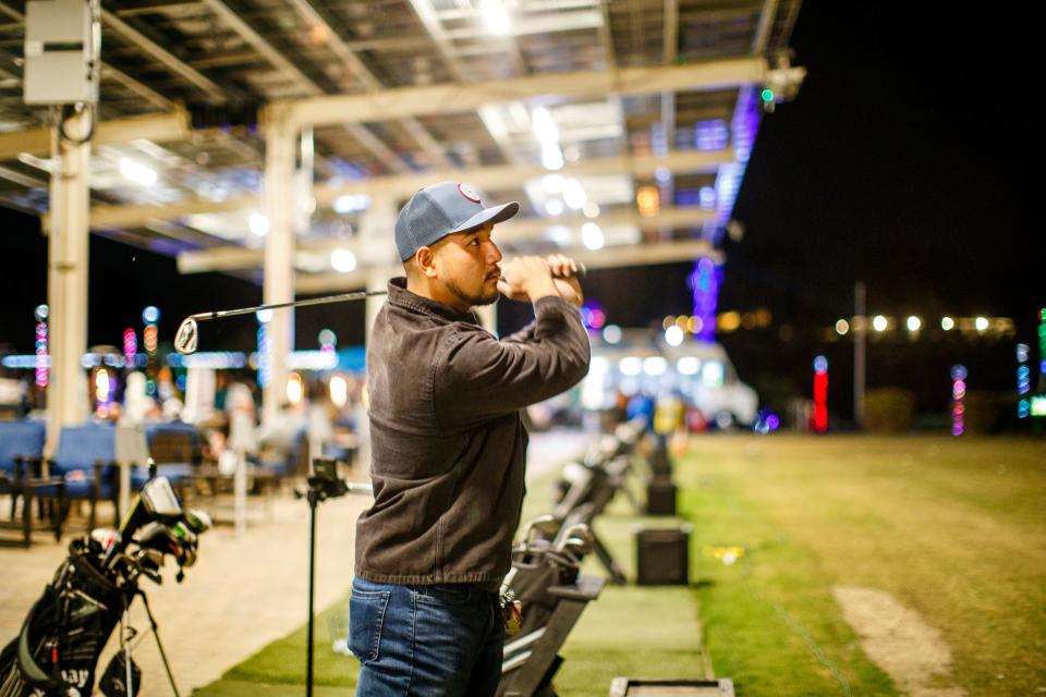 Rota Matsunaga watches his golf shot at the Shots in the Night driving range at the Indian Wells Golf Resort in Indian Wells, Calif., on Monday, Nov. 14, 2022. The event is available most days this holiday season as part of Indian Wells Winterfest.