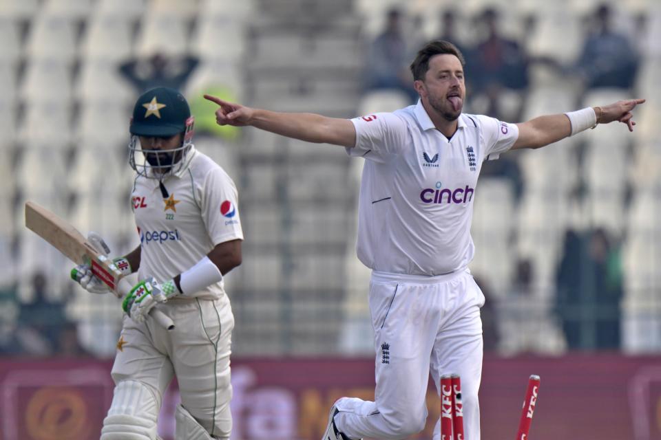 England's Ollie Robinson, right, celebrates after taking wicket of Pakistan Babar Azam, left, during the second day of the second test cricket match between Pakistan and England, in Multan, Pakistan, Saturday, Dec. 10, 2022. (AP Photo/Anjum Naveed)