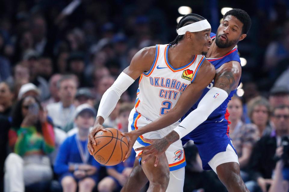 LA Clippers forward Paul George (13) defends Oklahoma City Thunder guard Shai Gilgeous-Alexander (2) during an NBA basketball game between the Oklahoma City Thunder and the Los Angeles Clippers at Paycom Center in Oklahoma City, Thursday, Feb. 22, 2024.