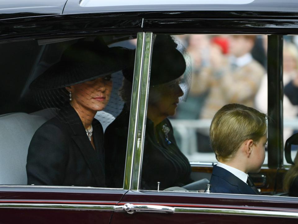 Kate Middleton, Queen Consort Camilla, and Prince George in a car.