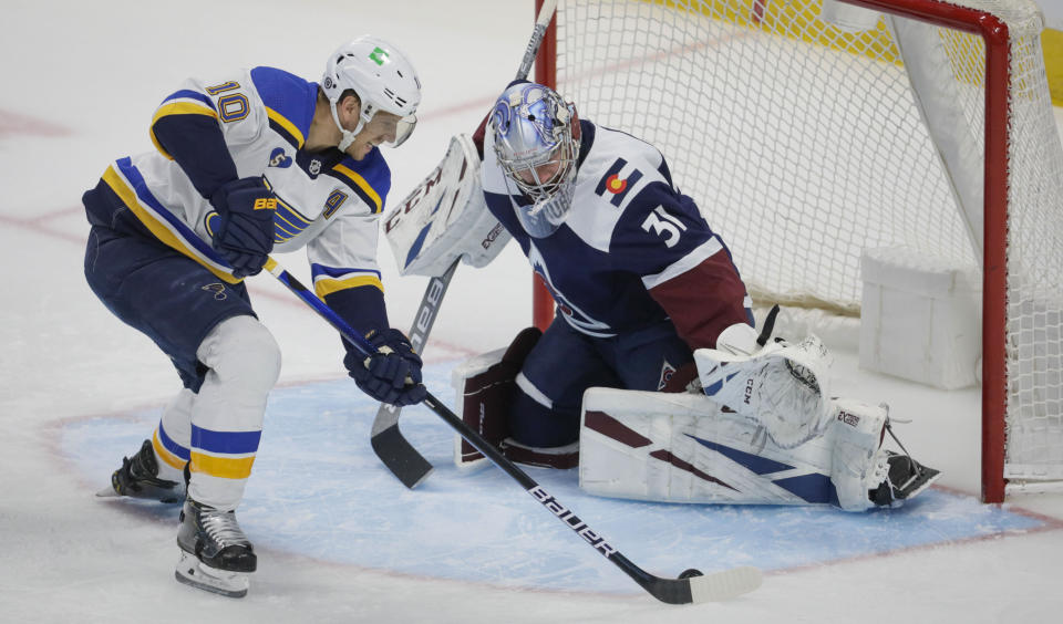 St. Louis Blues center Brayden Schenn (10) shoots on Colorado Avalanche goaltender Philipp Grubauer (31) during the first period of an NHL hockey game in Denver, Saturday, April 3, 2021. (AP Photo/Joe Mahoney)