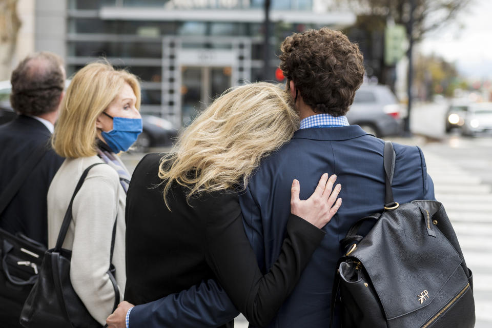 Former Theranos CEO Elizabeth Holmes, center, is comforted by her partner Billy Evans, right, after leaving federal court in San Jose, Calif., Thursday, Dec. 23, 2021. Her mother, Noel Holmes, is on the left, The jury began their third day of deliberations in her fraud and conspiracy trial on Thursday. (AP Photo/Nic Coury)