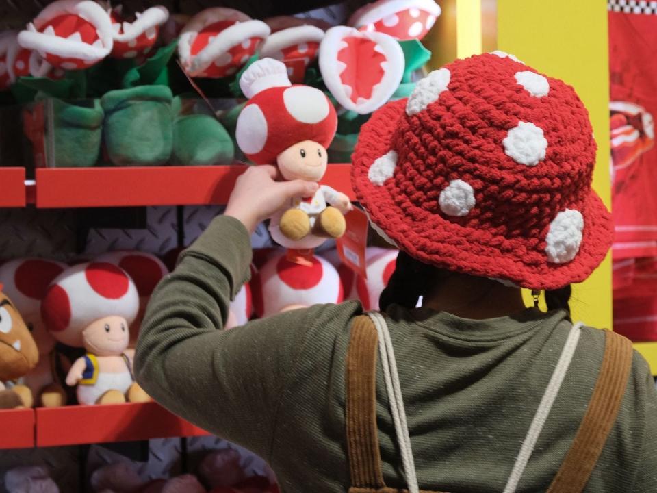 A guest looks at a Toad toy on display in a store during a preview of Super Nintendo World at Universal Studios in Los Angeles, California, on January 13, 2023.