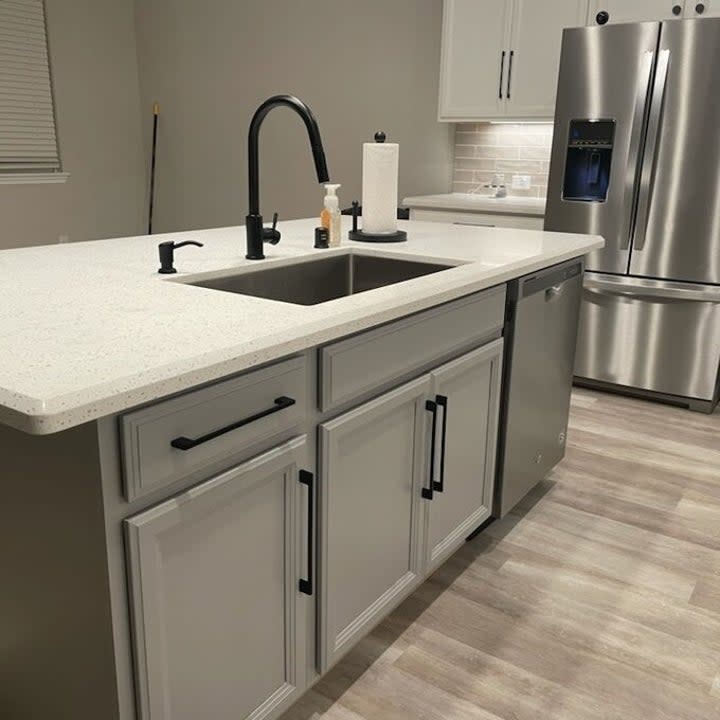 A user's photo of a black kitchen faucet on a white counter.
