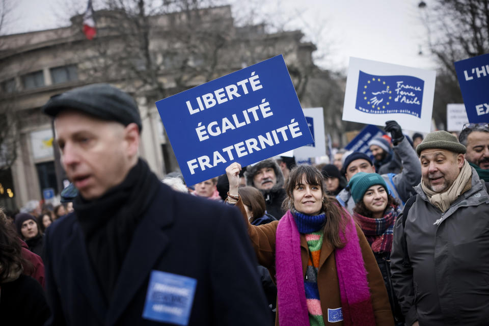 An opponent of France's immigration law holds a placard that reads, "freedom, equality, fraternity" during a protest in Paris, Sunday, Jan. 21, 2024. The Constitutional Council is reviewing next week the government's controversial immigration law , to check that measures is in line with the Constitution. (AP Photo/Thomas Padilla)