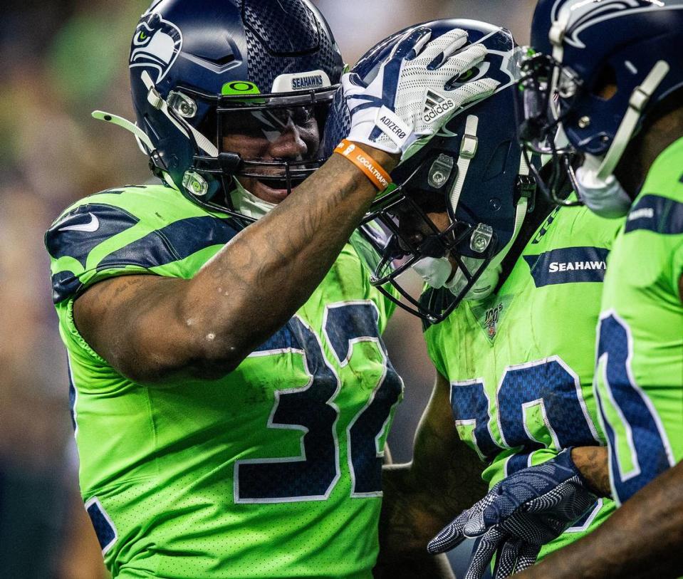 Seattle Seahawks running back Chris Carson (32) celebrates with Seattle Seahawks running back Rashaad Penny (20) after Penny’s touchdown run during the fourth quarter. The Seattle Seahawks played the Minnesota Vikings in a NFL football game at CenturyLink Field in Seattle, Wash., on Monday, Dec. 2, 2019.