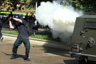 A demonstrator prepares to hit a riot police vehicle during a protest calling for changes in the education system in Santiago, Chile April 11, 2017. REUTERS/Ivan Alvarado