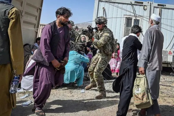 PHOTO: FILE - A US soldier point his gun towards an Afghan passenger at the Kabul airport in Kabul, Aug. 16, 2021, after a stunningly swift end to Afghanistan&#39;s 20-year war. (Wakil Kohsar/AFP via Getty Images, FILE)