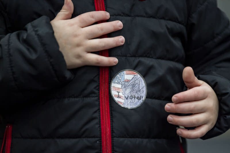 A boy puts on an "I voted" sticker after accompanying his mother to vote in the New Hampshire Primary in Windham, N.H., on Tuesday. Photo by Amanda Sabga/UPI