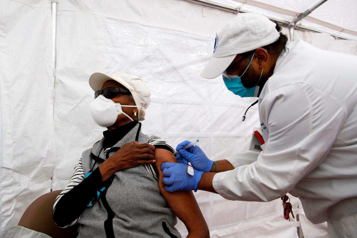 <p>El Dr. Jerry P. Abraham administra una vacuna Covid-19 a un anciano en una carpa de vacunación en el Centro de Salud Comunitario Kedren el 25 de enero de 2021 en Los Ángeles, California. - Si bien se da prioridad de vacunación a las personas, incluidos los trabajadores de la salud y los ancianos, algunos fuera de los niveles de prioridad están esperando en la fila para recibir potencialmente una dosis que debe administrarse antes de que expire y se desperdicie. </p> (Foto de PATRICK T.FALLON / AFP a través de Getty Images)