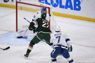 Minnesota Wild center Nick Bjugstad, center, hits the puck over the shoulder of Tampa Bay Lightning goalie Andrei Vasilevskiy to score as Lightning right wing Mathieu Joseph looks on during the first period of an NHL hockey game Sunday, Nov. 28, 2021, in St. Paul, Minn. (AP Photo/Craig Lassig)