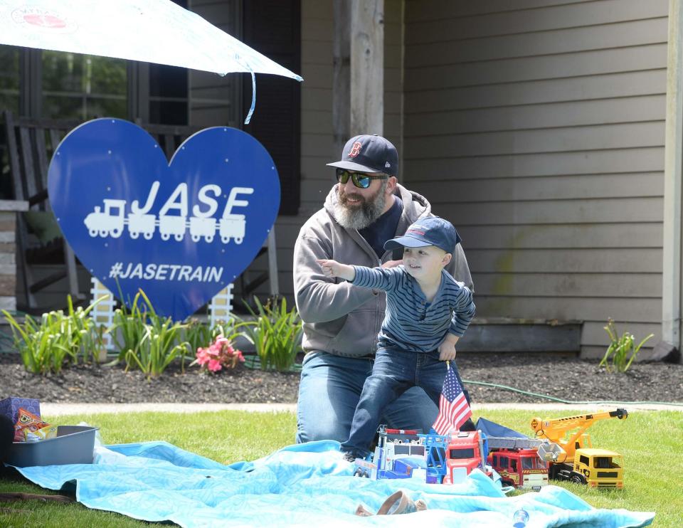 In this May 24, 2020, file photo, Jase Russell, 3, of West Bridgewater, who has neuroblastoma, points to vehicles taking part in a "Jase Train."