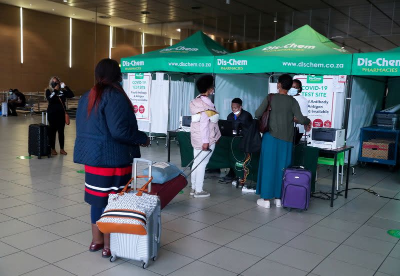 FILE PHOTO: Passengers queue to get a PCR test against COVID-19 before traveling on international flights, at O.R. Tambo International Airport in Johannesburg