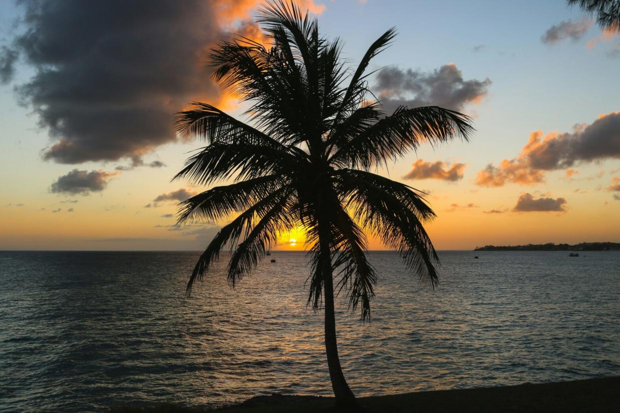Check out our report on the travel safety level of Barbados. pictured: a beautiful sunset on a Barbados beach