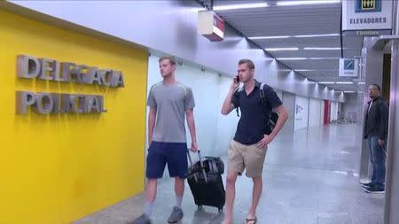 U.S. Olympic swimmers Gunnar Bentz and Jack Conger walk to the airport police station office at Rio's international airport in this still frame taken from video dated August 17, 2016, in Rio De Janeiro, Brazil. GLOBO TV/via REUTERS TV