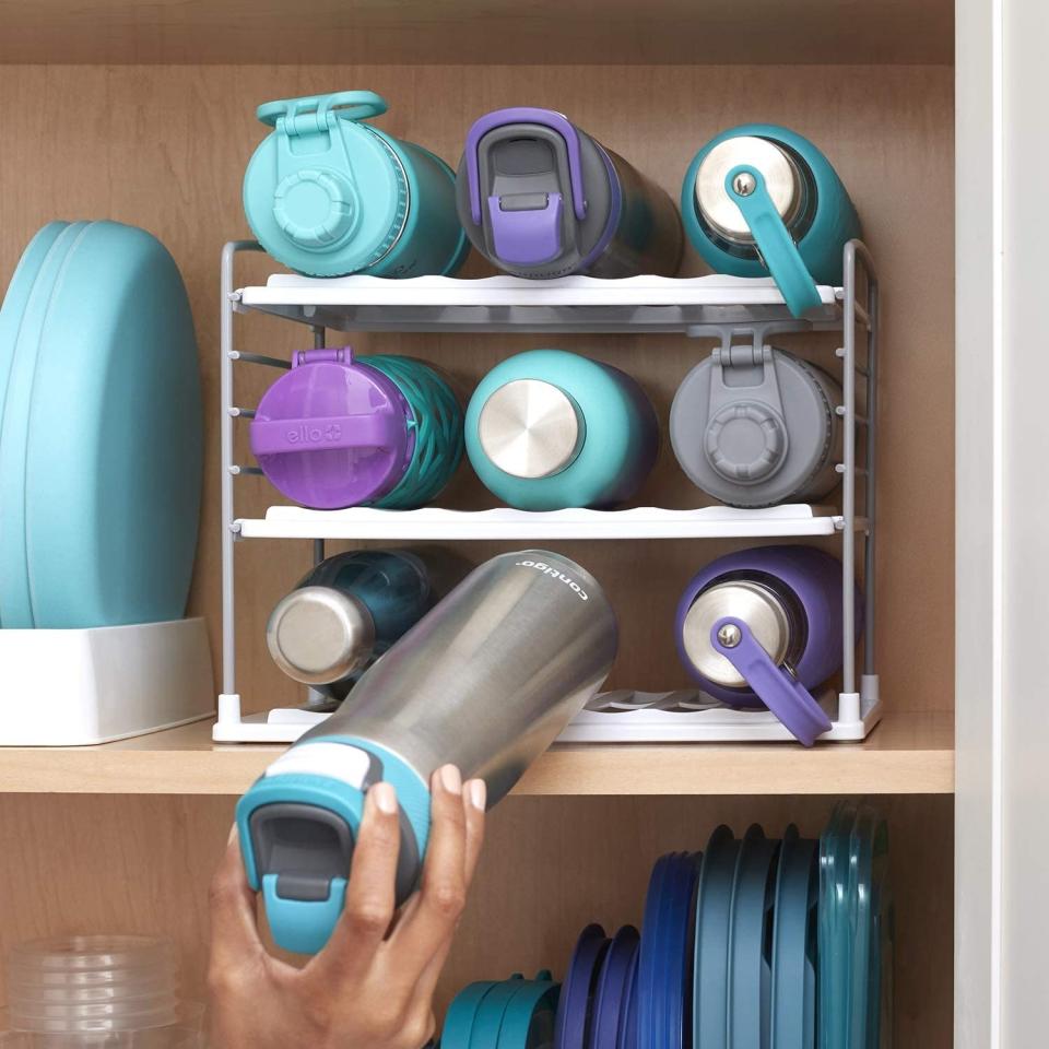 Model placing water bottle on storage rack in cabinet