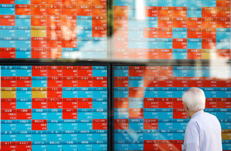 FILE PHOTO: A man looks at an electronic stock quotation board outside a brokerage in Tokyo, Japan, October 1, 2018. REUTERS/Toru Hanai