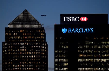 FILE PHOTO: Workers are seen in offices of HSBC and Barclays bank in the Canary Wharf financial district at dusk in London