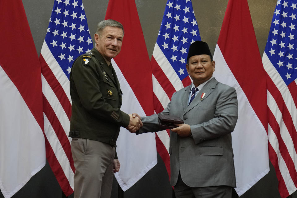 U.S. Army Chief of Staff Gen. James McConville, left, shakes hands with Indonesian Defense Minister Prabowo Subianto as they exchange souvenirs during their meeting in Jakarta, Indonesia, Friday, May 12, 2023. (AP Photo/Dita Alangkara)