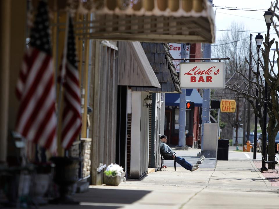 A man sits outside a bar in Greensburg, Indiana.