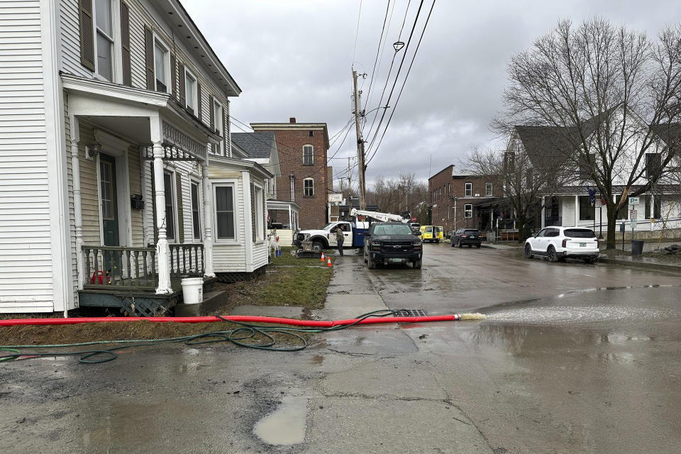 Water is pumped out of the basement of a home in Waterbury, Vt., on Tuesday, Dec. 19, 2023. Many communities were saturated by rainfall. Some towns in Vermont, which had suffered major flooding from a storm in July, were seeing more flood damage. (AP Photo/ Lisa Rathke)