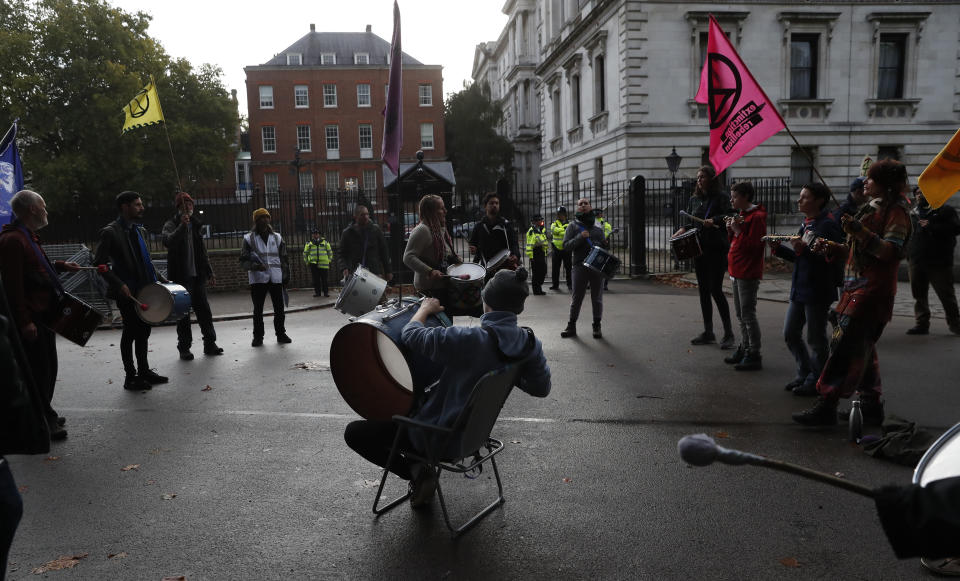 Climate change protesters play their drums at the rear of Downing Street in London, Tuesday, Oct. 8, 2019. Police are reporting they have arrested more than 300 people at the start of two weeks of protests as the Extinction Rebellion group attempts to draw attention to global warming. (AP Photo/Alastair Grant)