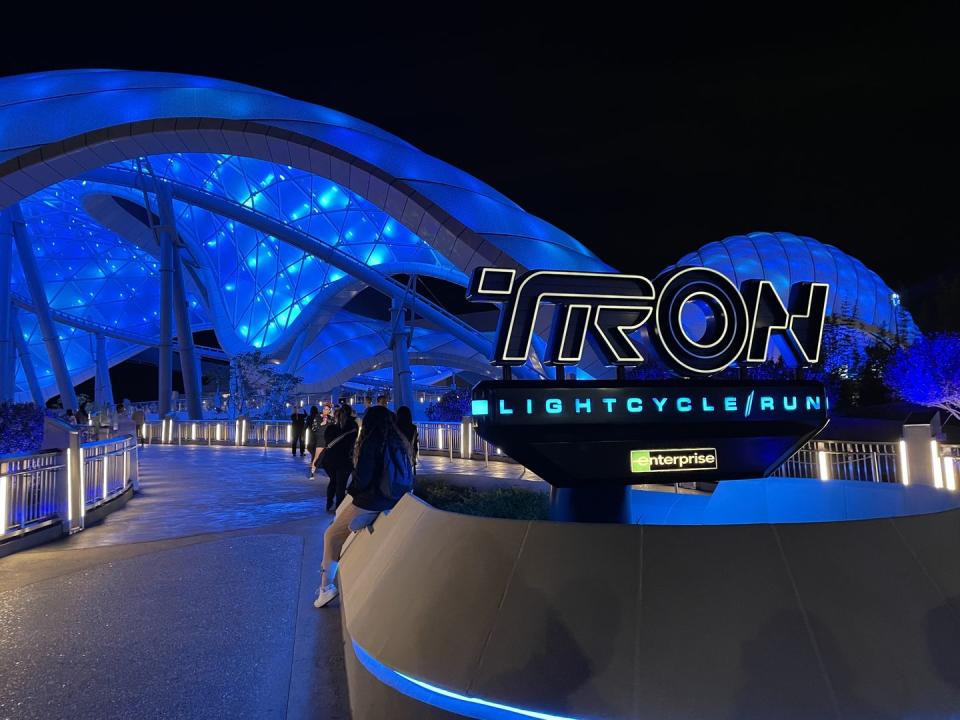 tron lightcycle run at disney world sign and ride lit up at night