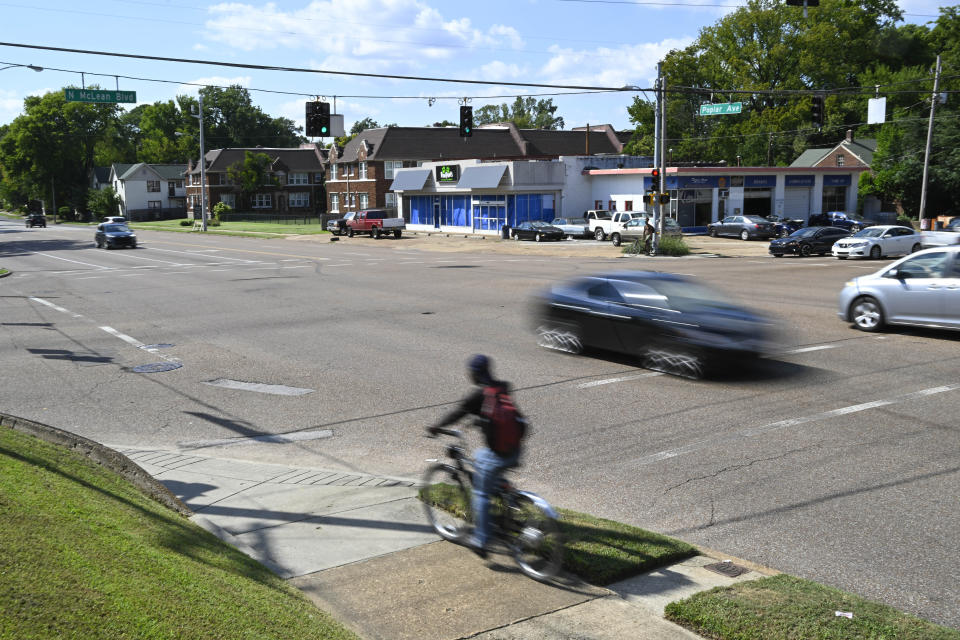 FILE - A bicyclist and motorists make their way down Poplar Ave. at the McLean Blvd. intersection, Thursday, Sept. 8, 2022, in Memphis, Tenn. The area is one of the places Ezekiel Kelly is accused of live streaming himself while driving around Memphis shooting at people. (AP Photo/John Amis, File)