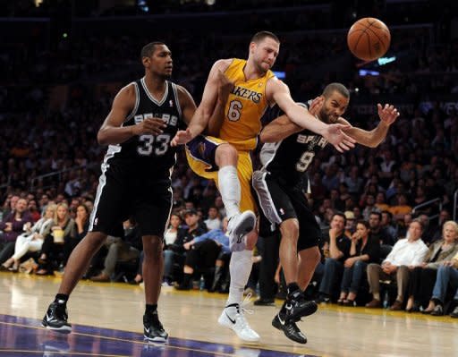 Josh McRoberts (C) of the Los Angeles Lakers goes for a rebound between Tony Parker (R) and Boris Diaw (L) of the San Antonio Spurs during their game on April 17. The Spurs won 112-91