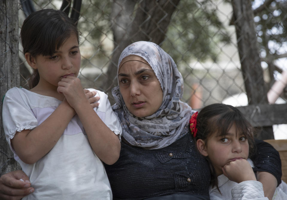 Somaya, the wife of Palestinian Osama Mansour, who was shot to death by Israeli soldiers at a temporary checkpoint in the occupied West Bank earlier this month, holds their 10 year-old twins Nissan, left and Bissan, right, at their family house, in the West Bank village of Biddu, west of Ramallah, Tuesday, April 20, 2021. Somaya, who was in the car with her husband and was wounded by the gunfire, says they followed the soldiers' instructions and posed no threat. The shooting death has revived criticism of the Israeli military's use of deadly force. (AP Photo/Nasser Nasser)