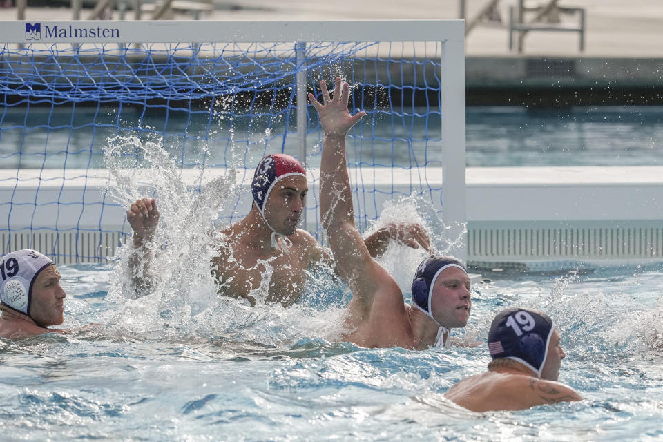 Ryder Dodd lifts his hand in front of goalkeeper Adrian Weinberg, during a training session Wednesday, Jan. 17, 2024, at Mount San Antonio College in Walnut, Calif. The U.S. water polo teams for the Olympics could have a much deeper connection than just a mutual love of their grueling sport. Chase and Ryder Dodd are trying to make the men's roster, alongside another pair of brothers in Dylan and Quinn Woodhead. Ella Woodhead, Dylan and Quinn's sister, is in the mix for the loaded women's squad. (AP Photo/Damian Dovarganes)