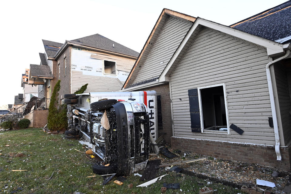 A truck lies on its side beside damaged homes on Sunday, Dec. 10, 2023, Clarksville, Tenn. Central Tennessee residents and emergency workers are continuing the cleanup from severe weekend storms. (AP Photo/Mark Zaleski)