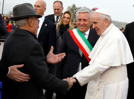 Pope Francis shakes hands with 99-year-old Umberto Orlando during his pastoral visit in Pietrelcina, Italy March 17, 2018. REUTERS/Ciro De Luca