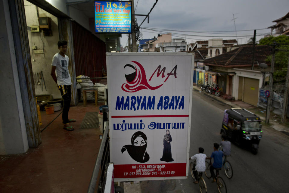 A billboard displays garments worn by Muslim women, at a women's clothing shop in Kattankudy, Sri Lanka, Monday, April 29, 2019. After being targeted by Islamic State suicide bombings on Easter, Sri Lanka has banned the niqab face veil, which increasingly has been seen in Muslim areas of the island nation's east. (AP Photo/Gemunu Amarasinghe)