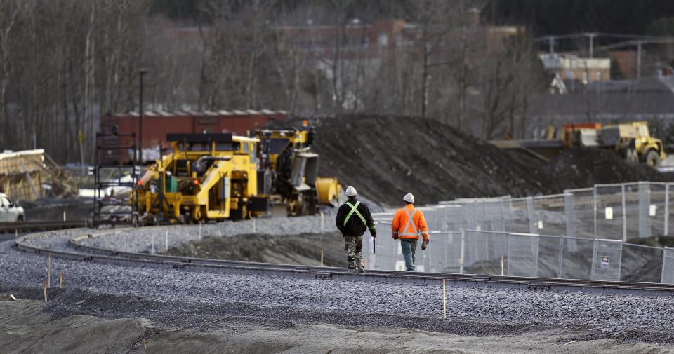 Workers walk on the rail track in Lac-Megantic