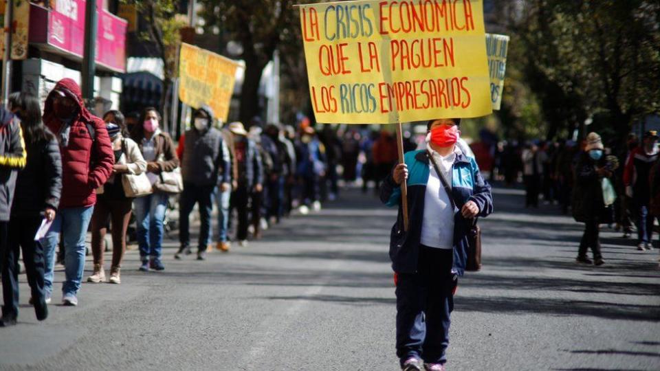 Una mujer con una mascarilla en una manifestación