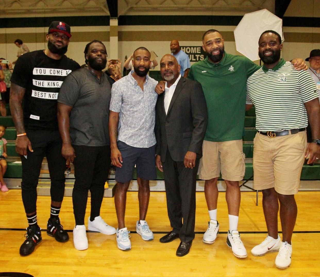 St. Vincent-St. Mary High School basketball coach Dru Joyce II (third from right) is joined by (from left) LeBron James, Sian Cotton, Dru Joyce III, Romeo Travis and Willie McGee after the dedication ceremony to name STVM's court Coach Dru Joyce Court at LeBron James Arena, Sunday, July 24, 2022.