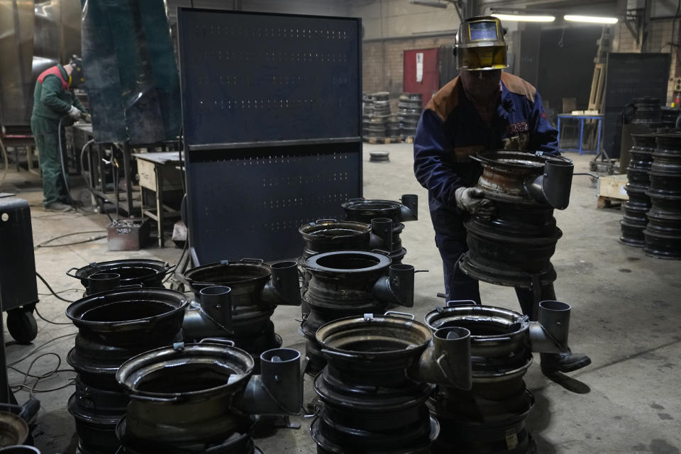 A volunteer carries a stove after welding several rims together in a workshop in of Siauliai, some 230 km (144 miles) north-west of the capital Vilnius, Lithuania, Thursday, Feb. 2, 2023. Since Russia invaded Ukraine last February, Lithuania, Latvia and Estonia — three states on NATO’s eastern flank scarred by decades of Soviet-era occupation — have been among the top donors to Kyiv. (AP Photo/Sergei Grits)