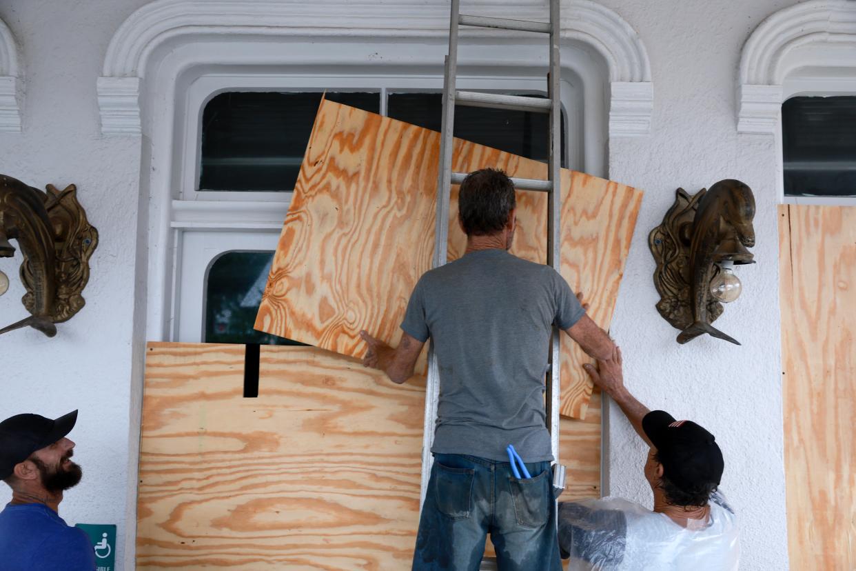 Workers place plywood over the windows of a business as they prepare for the arrival of Hurricane Debby, which has strengthened as it moves through the Gulf of Mexico in Cedar Key, Florida (Getty Images)