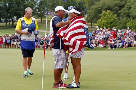 Aug 20, 2017; West Des Moines, IA, USA; USA golfer Lizette Salas has the American flag draped on her by her caddie after wining to the match to retain The Solheim Cup international golf tournament at Des Moines Golf and Country Club. Mandatory Credit: Brian Spurlock-USA TODAY Sports