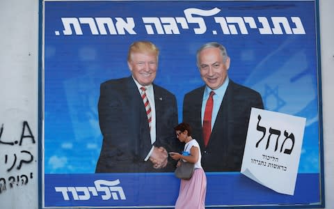 A woman walks past a Likud party election campaign banner depicting Israeli Prime Minister Benjamin Netanyahu and Donald Trump in Tel Aviv - Credit: &nbsp;CORINNA KERN/&nbsp;REUTERS